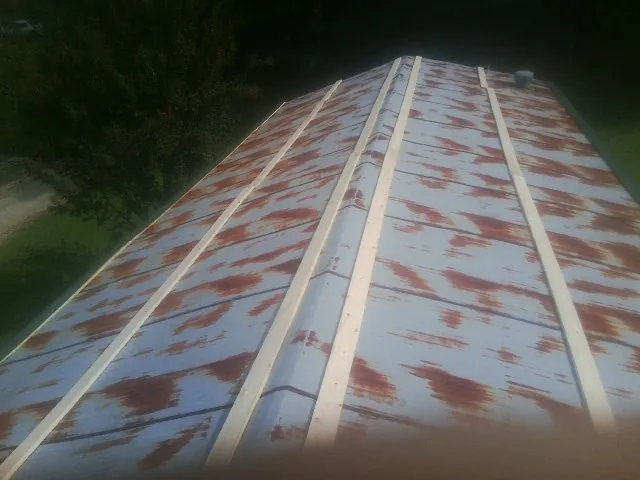 Rusted metal roof panels with new wood purlins before replacement — Storm Damage Roof Repair in Arlington by Roofing Brothers